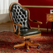 Black leather presidential armchair with high back and armrests, mounted on a swivel base with wheels.