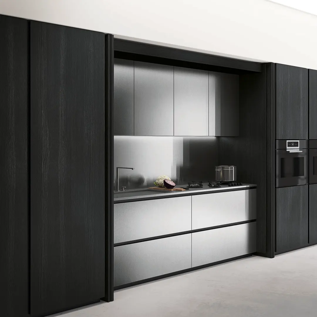 Cucina su misura con isola in Acciaio Inox • In questo progetto esclusivo, abbiamo creato una cucina su misura che fonde la calda eleganza delle ante in finitura noce con la modernità sofisticata dell’isola in acciaio inox. Il risultato è uno spazio che rappresenta il perfetto equilibrio tra tradizione e innovazione.